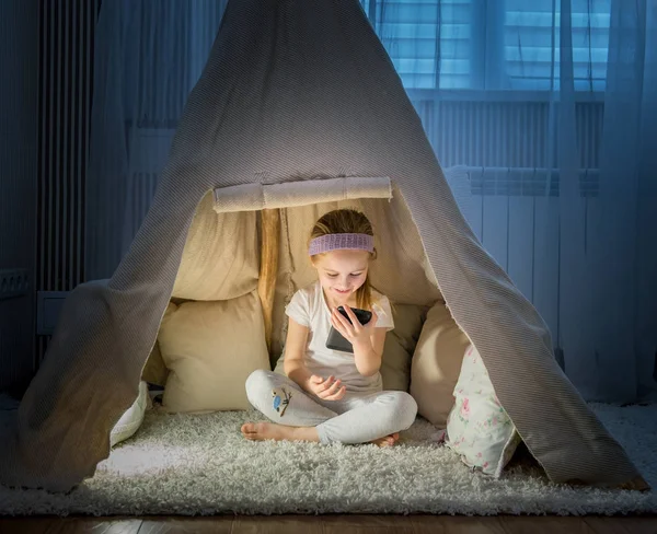 Menina na tenda teepee no quarto — Fotografia de Stock