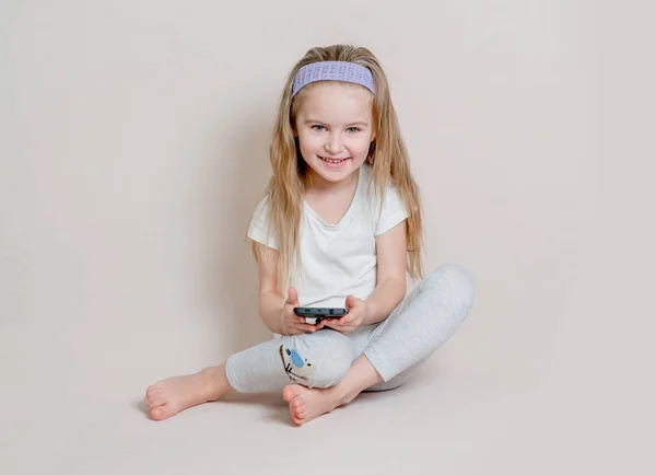 Маленькая девочка в пигамах сидит на полу — стоковое фото