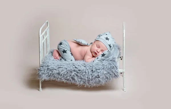 Сладкий новорожденный мальчик на детской кроватке спит — стоковое фото