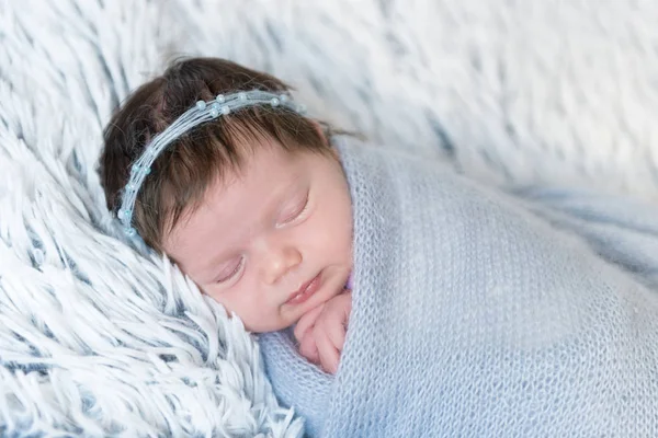 Novorozence dívka v modrých zábal — Stock fotografie