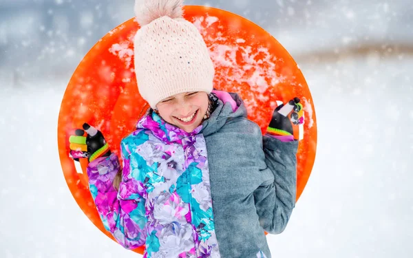 Menina engraçada com disco de trenó ao ar livre — Fotografia de Stock