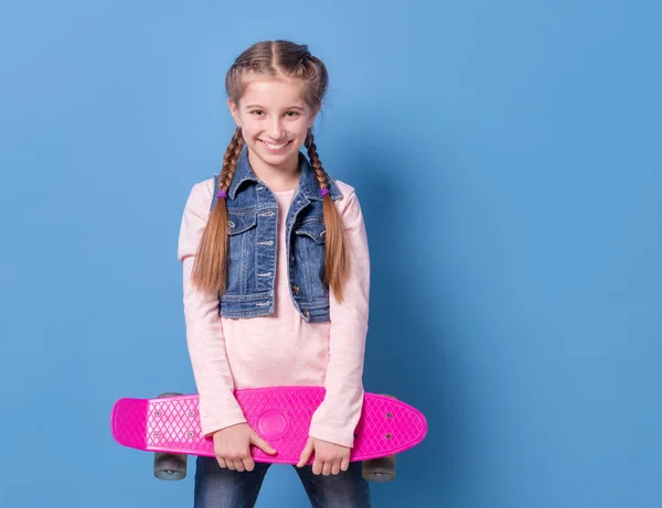 Tienermeisje met roze skateboard — Stockfoto