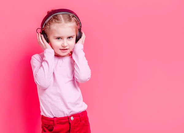 Little girl in headphones over rose background — Stock Photo, Image