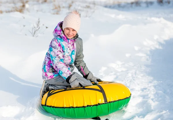 Meisje met snowtube op besneeuwde afdaling — Stockfoto