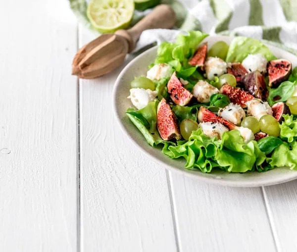 Ensalada con higos, mozzarella y uvas sobre fondo de madera blanca . —  Fotos de Stock