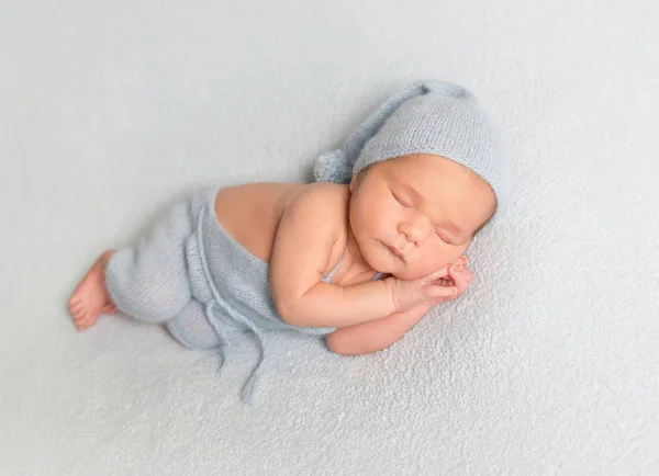 Bébé garçon recroquevillé sur couverture blanche — Photo