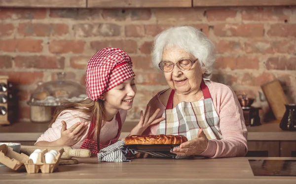 Cucu kecil dengan nenek menikmati pie buah buatan sendiri — Stok Foto