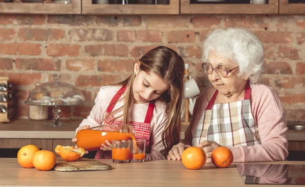 Neta fazendo suco de laranja com a avó — Fotografia de Stock