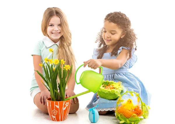 Dos niñas regando flores y jugando en el suelo — Foto de Stock