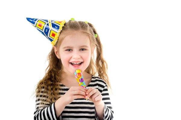 Μικρό ξανθό κορίτσι με καπέλο πολύχρωμο πάρτυ χρησιμοποιώντας κόμμα φυσητήρας — Φωτογραφία Αρχείου