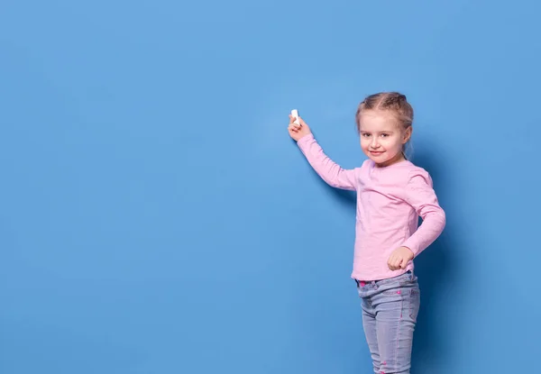 Κοριτσάκι με κιμωλία σε μπλε φόντο — Φωτογραφία Αρχείου