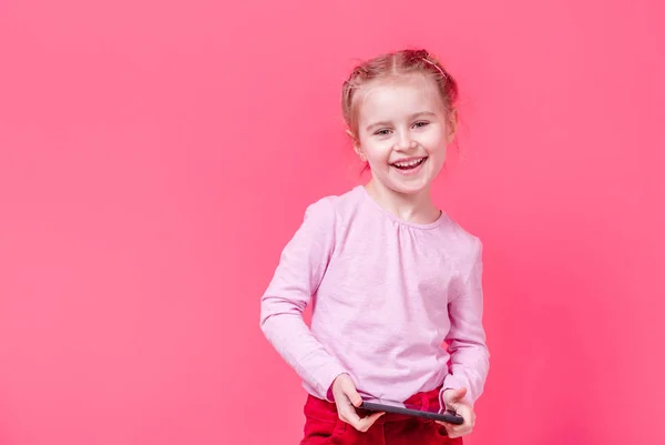 Sonriente niña sosteniendo el teléfono móvil —  Fotos de Stock