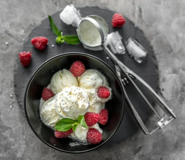 Helado con frambuesas servido en piala negra —  Fotos de Stock