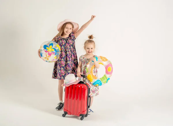 Irmãs felizes estão perto de uma mala — Fotografia de Stock
