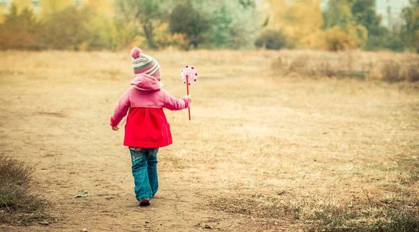 Маленька дівчинка гуляє з вітряком — стокове фото