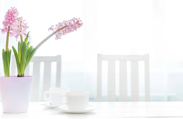 Koppar kaffe med hyacint blommor på tabellen vit — Stockfoto