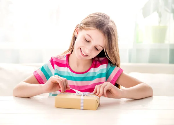 Ragazza sorridente scartando scatola regalo — Foto Stock