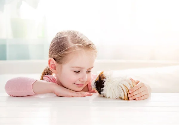 Smiling little girl hugging guinea pig — Stock Photo, Image