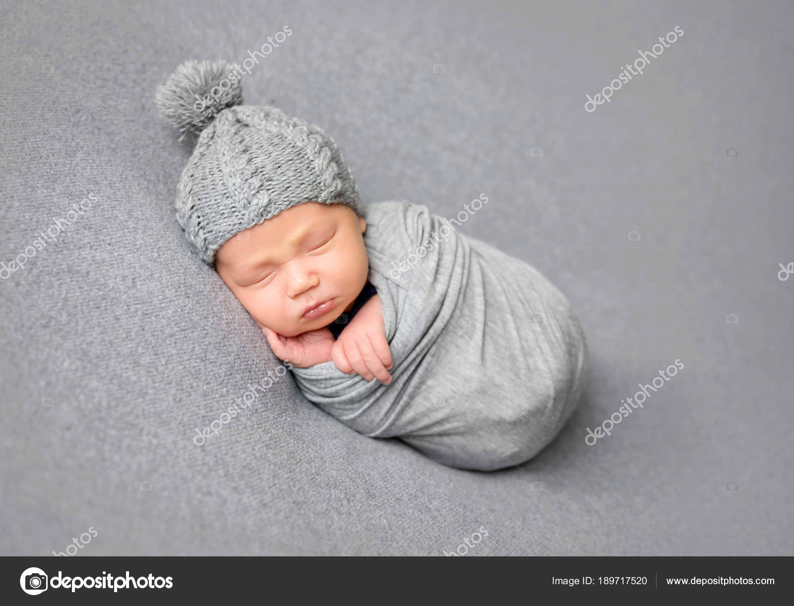 Newborn baby sleeping curled up in grey blanket — Stock Photo © tan4ikk