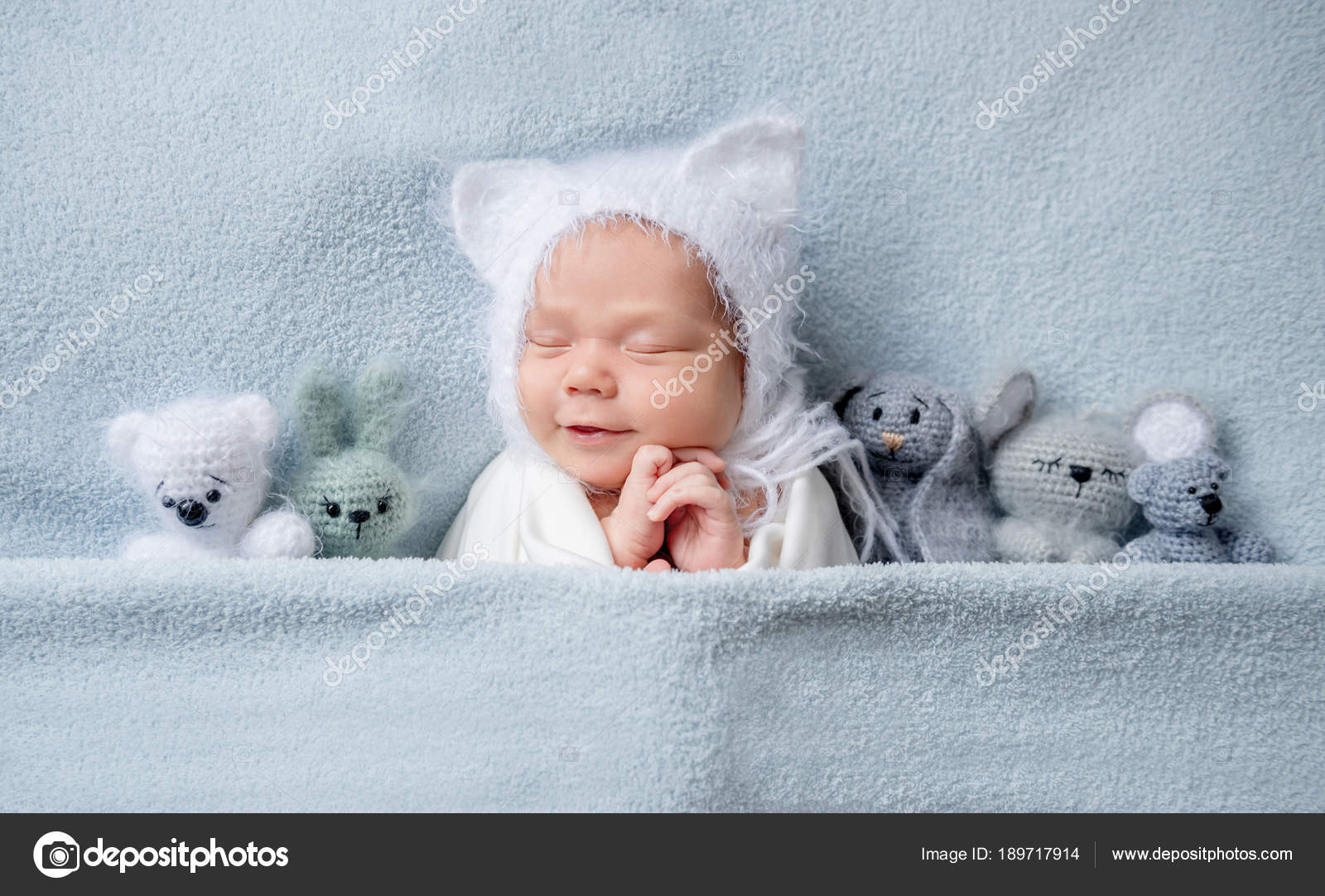 Infant child in with ears sleeping with toys Stock Photo by