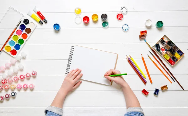 Girls hand with pencil over blank paper — Stock Photo, Image