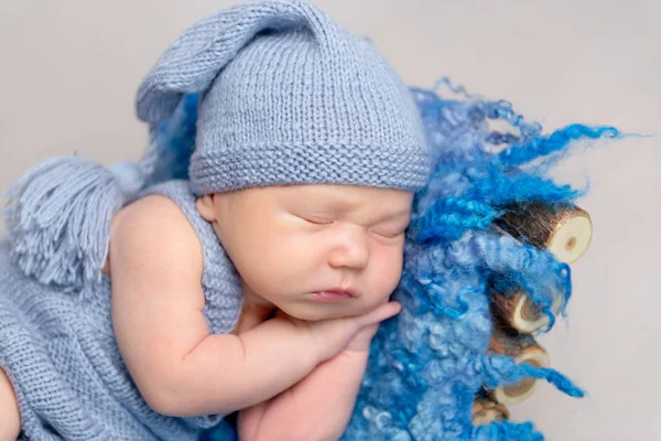 Bayi berpakaian dalam kostum kuning rajutan tidur di tempat tidur bayi — Stok Foto