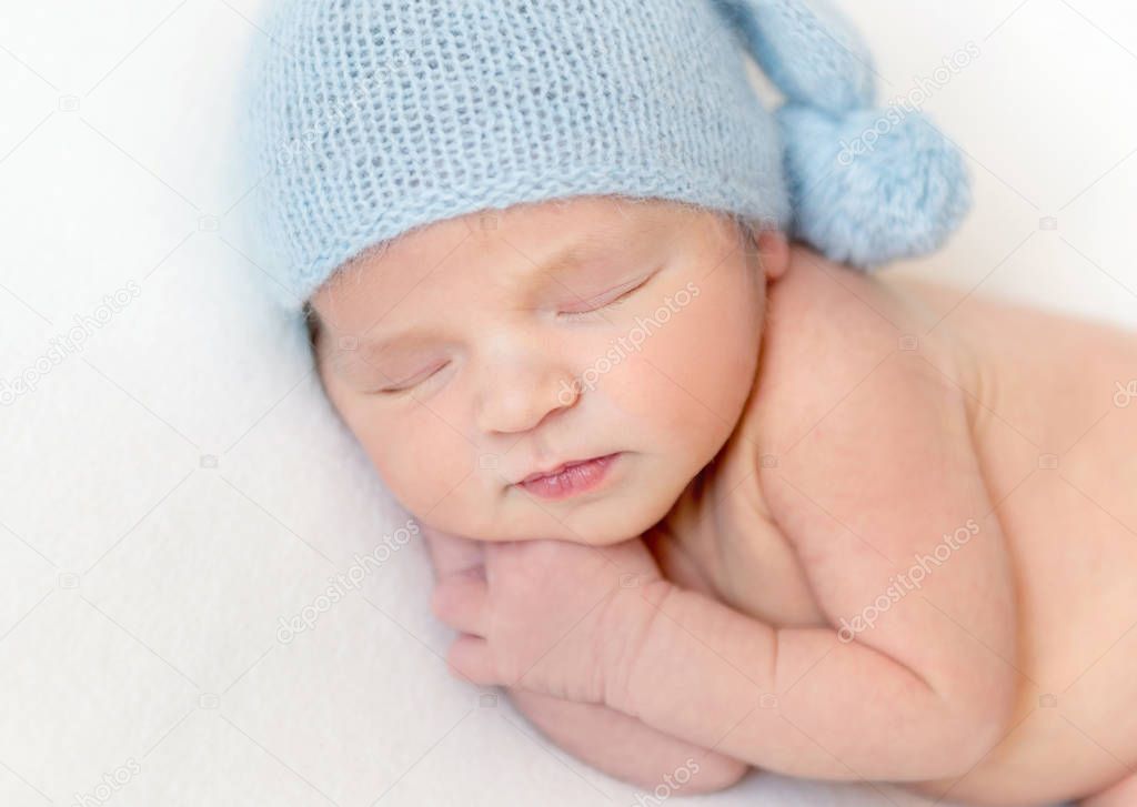 Portrait of newborn little baby in blue bonnet