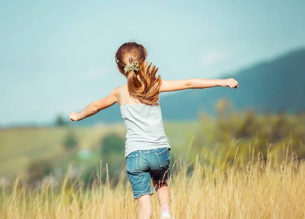 Niña corre a través de un prado —  Fotos de Stock