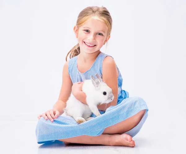 Mignonne petite fille un lapin blanc — Photo