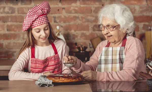 Avó com sua neta cozinhar torta — Fotografia de Stock