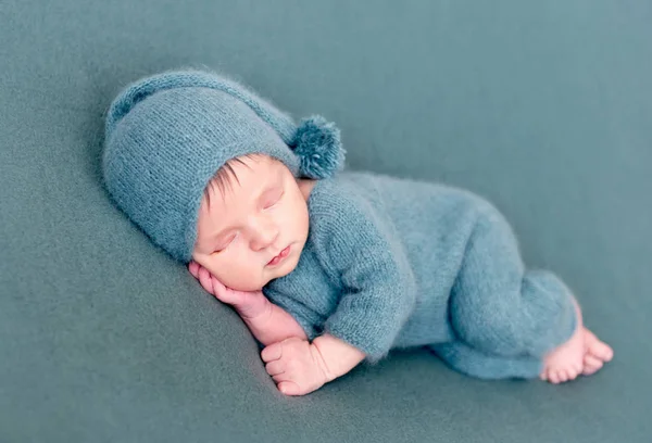 Menino infantil dormindo em traje de lã com os pés descalços — Fotografia de Stock