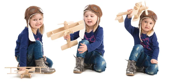 Мила маленька дівчинка в капелюсі пілота з дерев'яною площиною — стокове фото