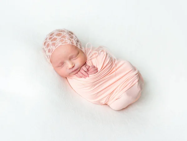 Bir pembe şal içinde uyuyan newboen bebek — Stok fotoğraf
