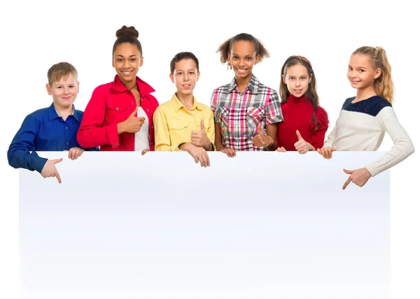 Adolescentes con pulgares hacia arriba apuntando a un anuncio en blanco — Foto de Stock