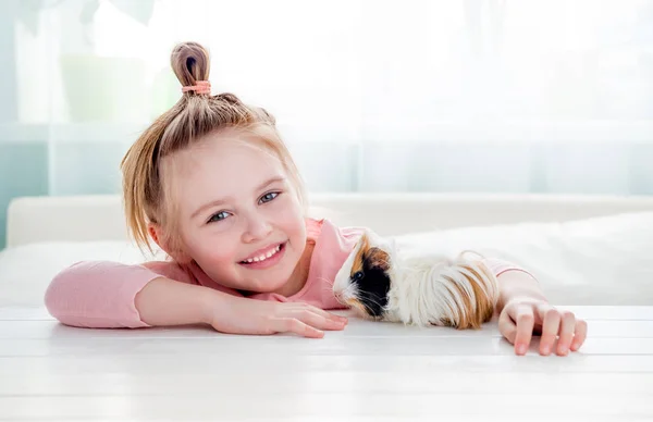 Smiling little girl hugging guinea pig