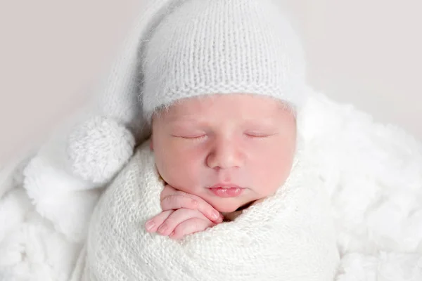 Newborn baby in white wrap laying on basket — Stock Photo, Image