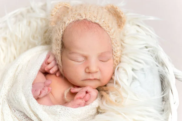 Nyfött barn i roliga bonnet tupplur i korg — Stockfoto