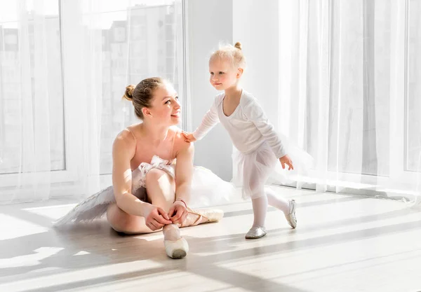 Маленьку дівчинку вчать зав'язувати взуття для балету — стокове фото