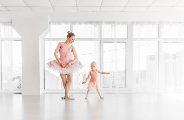 Giovane splendida ballerina con la sua piccola figlia che balla in studio — Foto Stock