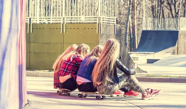 Longboards 坐在 skatepark 的女孩的后面视图 — 图库照片