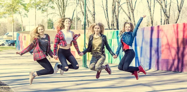 Giovani ragazze che si tengono per mano e saltano insieme — Foto Stock