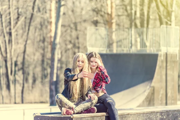 Belle ragazze in abiti casual facendo selfie allo skate park — Foto Stock