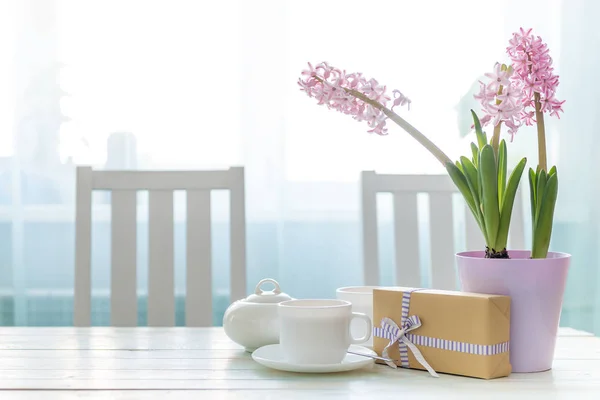 Presentera box med koppar och blommor på bordet — Stockfoto