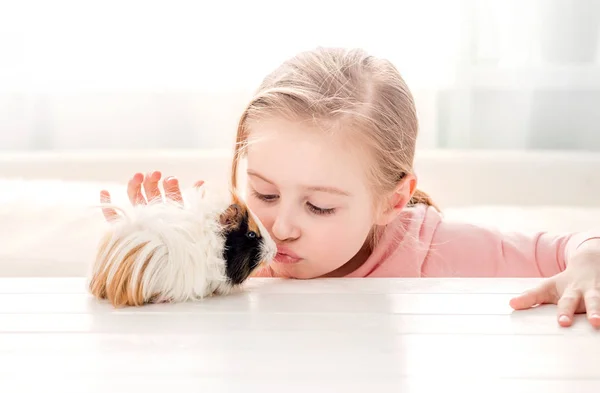 Little girl kissing guinea pig — Stock Photo, Image