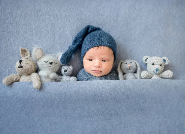 Lindo niño recién nacido acostado bajo una manta azul — Foto de Stock