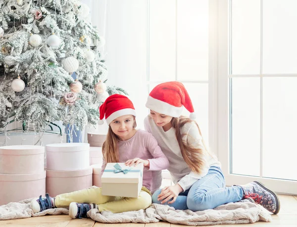 Сёстры открывают новогодние подарки — стоковое фото