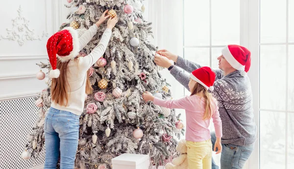 Vader en dochters versieren kerstboom — Stockfoto