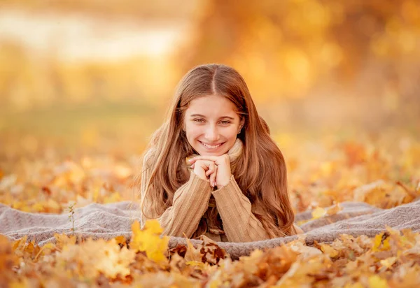 Девушка сидит в желтых листьях — стоковое фото