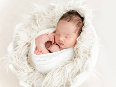 küçük bir yastık üzerinde uyuyan yeni doğan bebek