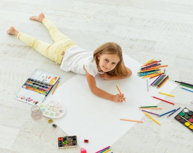 küçük kız yerde yatan küçük neşeli kız çizer yerde yatan çizer